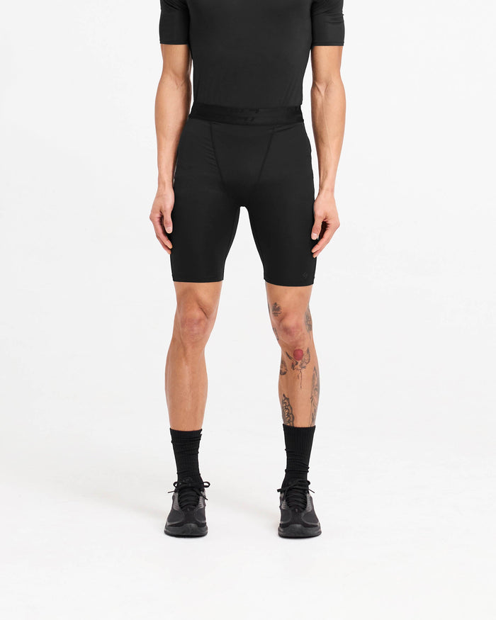 Man wearing black legging shorts on a plain white background | 247 Compound Legging Short in Black | Training shorts with branded waistband and fused pocket | 247 Shorts | Represent Clo