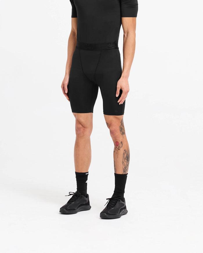 Man wearing black legging shorts on a plain white background | 247 Compound Legging Short in Black | Performance shorts with elasticated waistband and fused pocket | 247 Shorts | Represent Clo