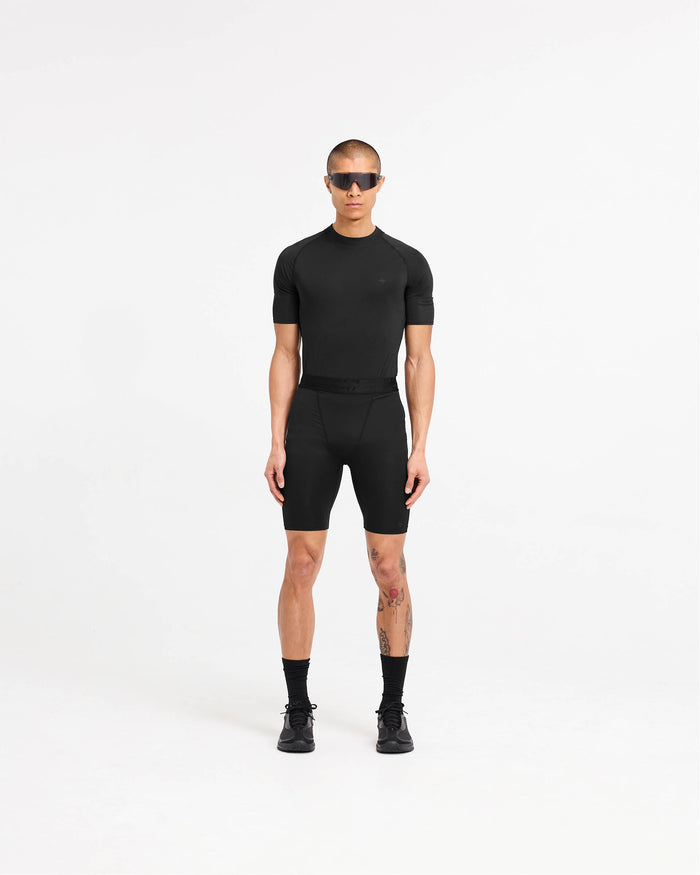 Man wearing black legging shorts on a plain white background | 247 Compound Legging Short in Black | Legging shorts with branded waistband | 247 Shorts | Represent Clo
