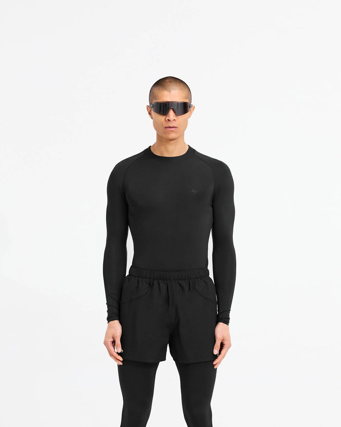 Man wearing a black long sleeve t-shirt on a plain white background | 247 Compound Long Sleeve T-Shirt in Black | Performance t-shirt with raglan sleeves and flatlock stitching | 247 T-Shirts | Represent Clo