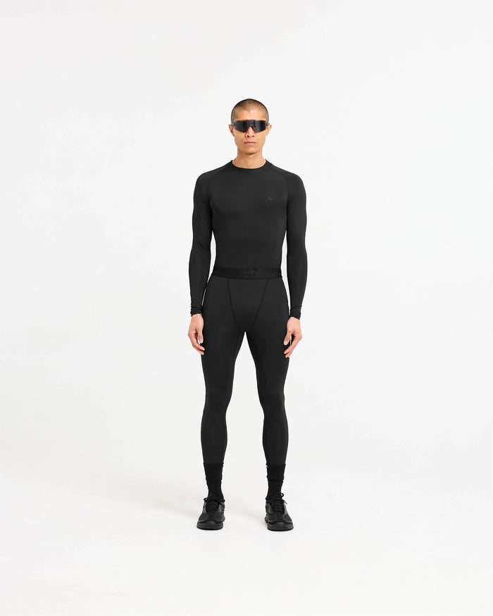 Man wearing a black long sleeve t-shirt on a plain white background | 247 Compound Long Sleeve T-Shirt in Black | Matte black t-shirt with raglan sleeves and 4-way stretch | 247 T-Shirts | Represent Clo