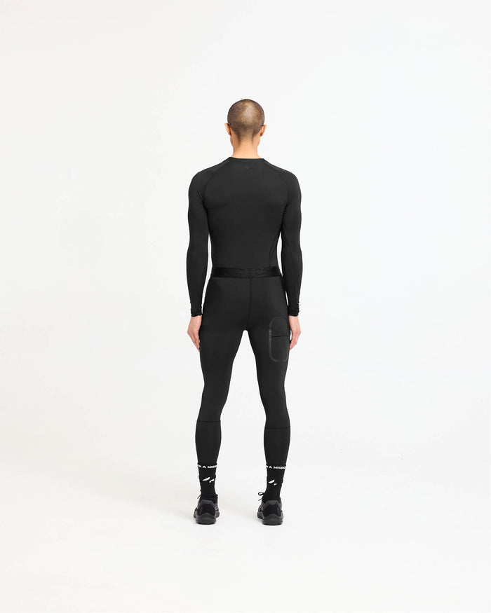 Man wearing a black long sleeve t-shirt on a plain white background | 247 Compound Long Sleeve T-Shirt in Black | Raglan sleeves with quick drying fabric | 247 T-Shirts | Represent Clo