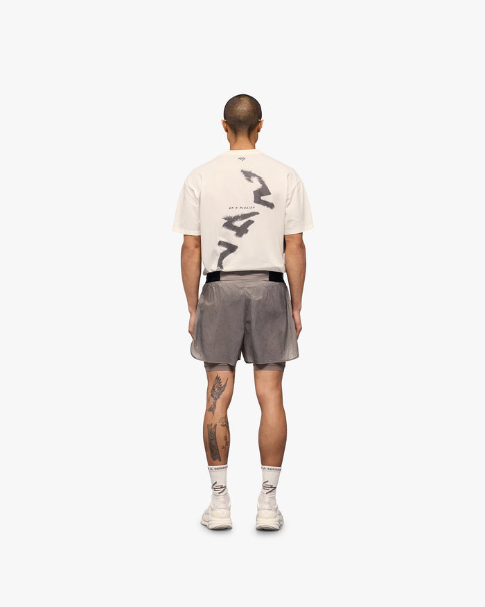 Man wearing grey 2-in-1 run shorts on a plain white background | 247 Contour 2-In-1 Run Shorts in Pebble | Shorts with inner legging and zip pockets | 247 Shorts | Represent Clo