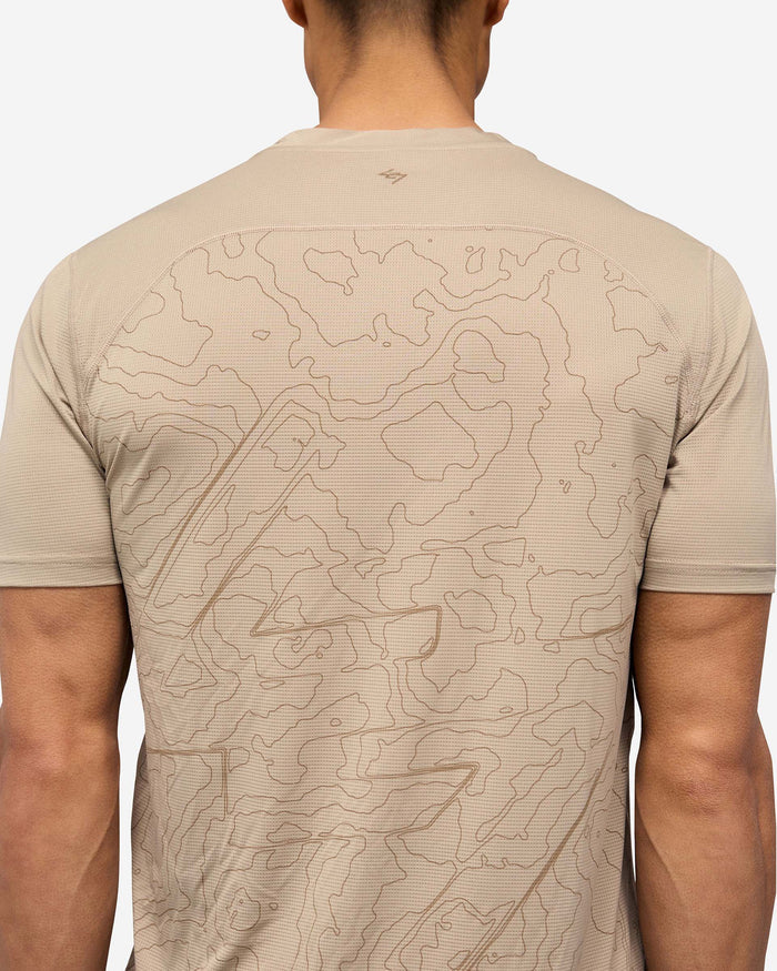 Man wearing a grey technical t-shirt on a plain white background | 247 Contour Run T-Shirt in Pebble | Breathable running t-shirt with contour back print | 247 T-Shirts | Represent Clo