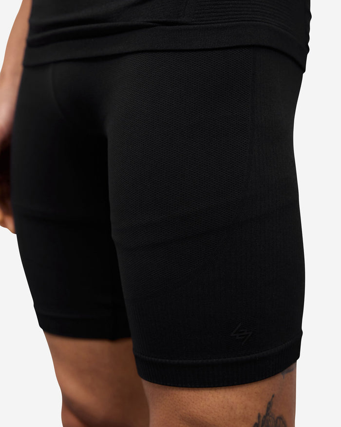 Man wearing black seamless shorts on a plain white background | 247 DNA Seamless Shorts in Black | Compression support seamless shorts | 247 Shorts | Represent Clo