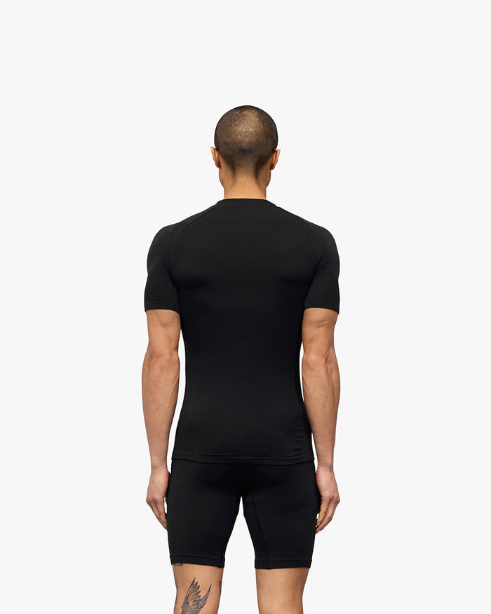 Man wearing a black seamless t-shirt on a plain white background | 247 DNA Seamless T-Shirt in Black | Seamless slim fit t-shirt for performance | 247 T-Shirts | Represent Clo