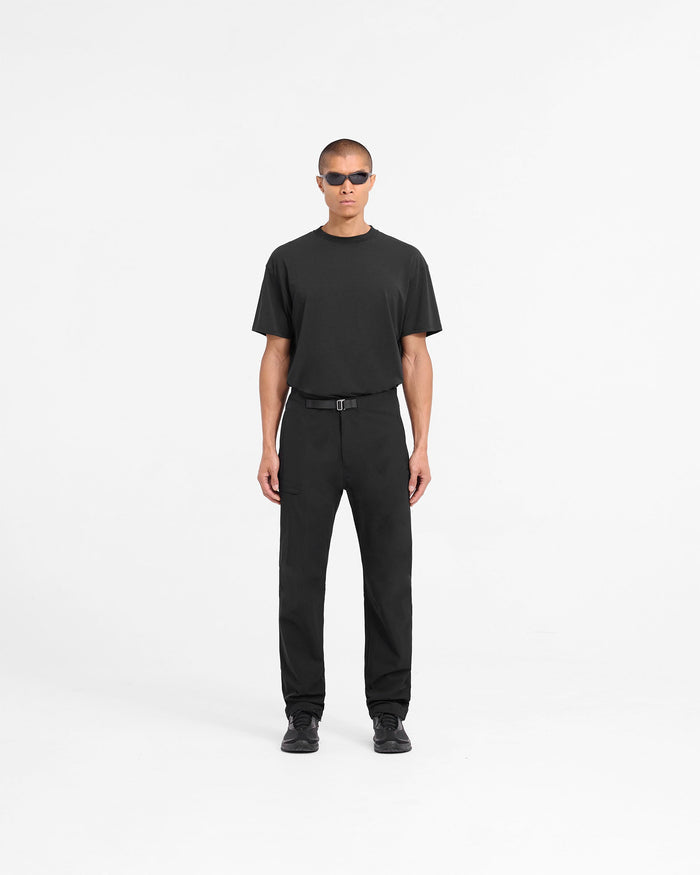 Man wearing black pants on a plain white background | 247 Mission Pant in Black | Straight leg pants with built-in belt and zip pockets | 247 Pants | Represent Clo