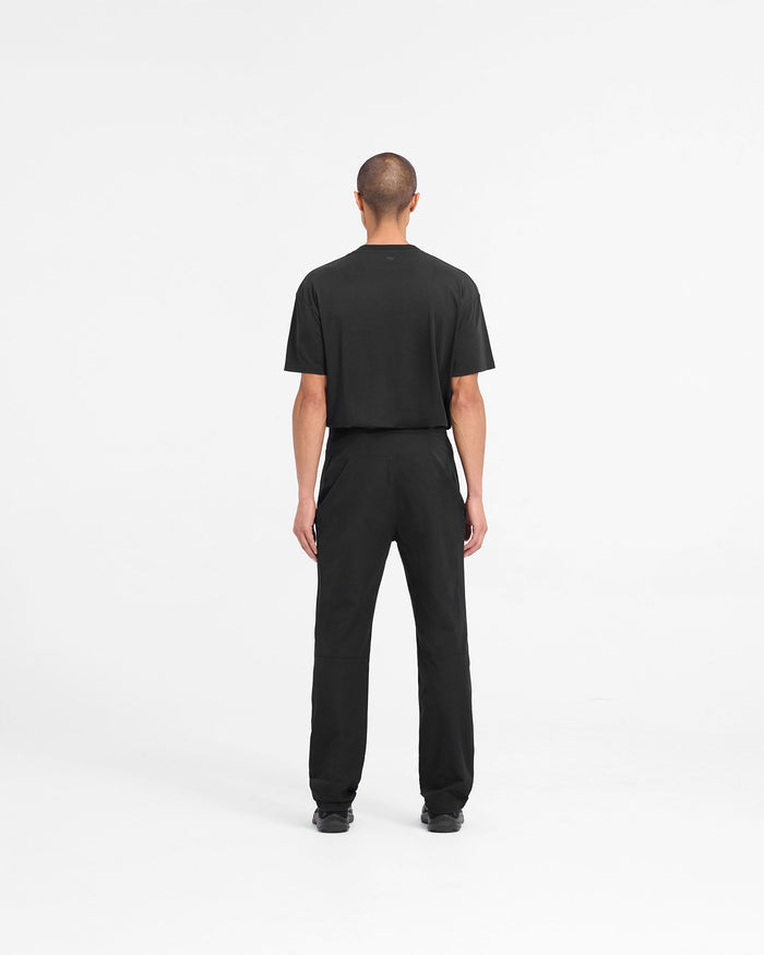 Man wearing black pants on a plain white background | 247 Mission Pant in Black | Durable mens pants with built-in belt and zip pockets | 247 Pants | Represent Clo