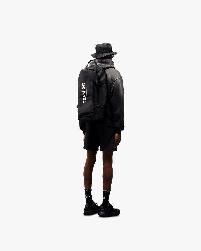 Man wearing an oversized black hoodie on a plain white background | 247 Motion Oversized Hoodie in Black | Oversized fit hoodie with 247 motion print | 247 Hoodies | Represent Clo