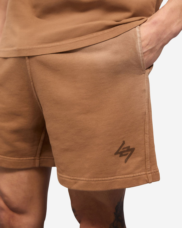 Man wearing rust shorts on a plain white background | 247 Motion Shorts in Rust | Jersey shorts with elasticated waistband and vintage aesthetic | 247 Shorts | Represent Clo