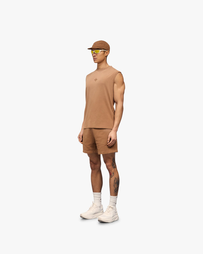 Man wearing rust shorts on a plain white background | 247 Motion Shorts in Rust | Jersey shorts with elasticated waistband and graphic print | 247 Shorts | Represent Clo