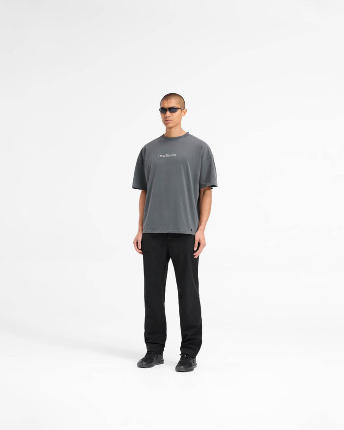 Man wearing a black oversized t-shirt on a plain white background | 247 On A Mission Oversized T-Shirt in Aged Black | Slightly oversized t-shirt with embroidery and distressing details | 247 T-Shirts | Represent Clo
