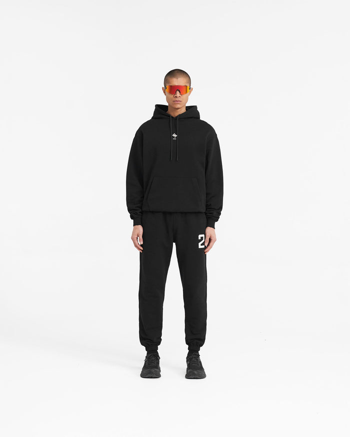 Man wearing an oversized black hoodie on a plain white background | 247 Oversized Hoodie in Jet Black | Black training hoodie with ribbed cuffs and hem | 247 Hoodies | Represent Clo