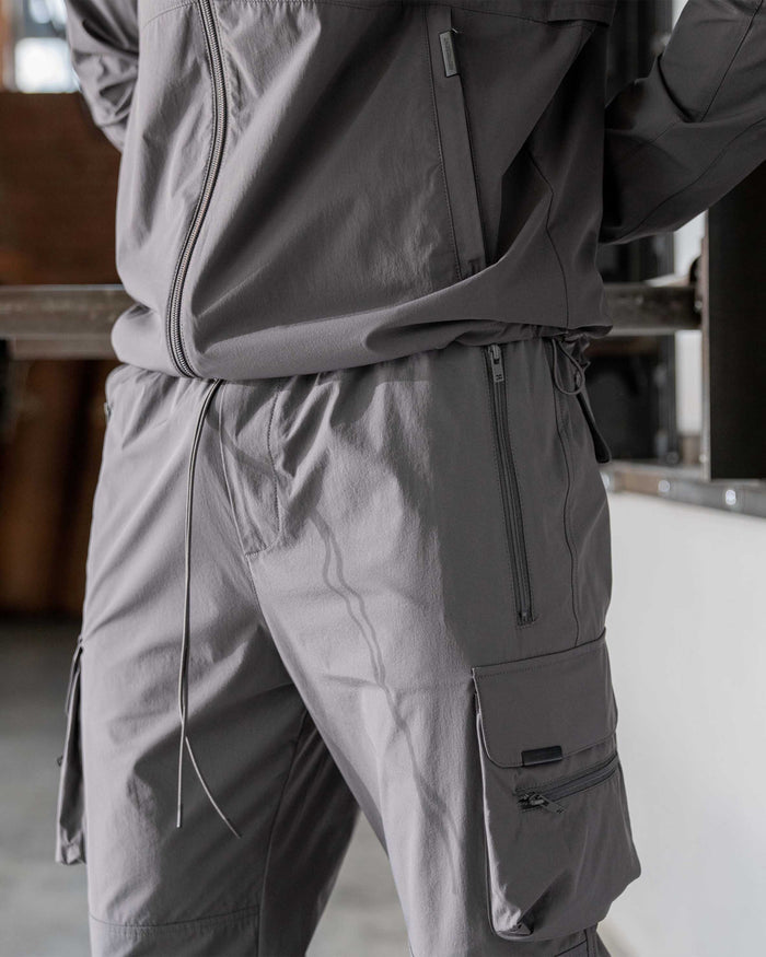 Man wearing grey cargo pants on a plain white background | 247 Pant in Grey | Cargo pants with 4-way stretch and zip side pockets | 247 Pants | Represent Clo