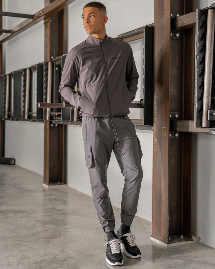 Man wearing grey versatile cargo pants on a plain white background | 247 Pant in Grey | Cargo pants with 4-way stretch and cargo pockets | 247 Pants | Represent Clo