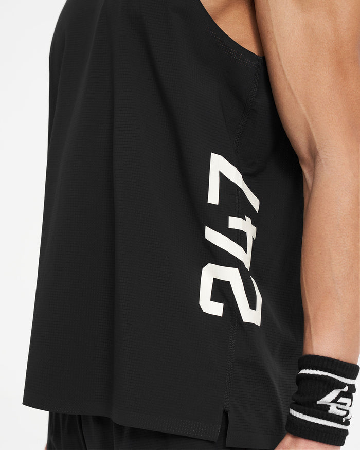 Man wearing a black singlet on a plain white background | 247 Singlet in Jet Black | Perforated training vest with stretch ripstop fabric | 247 T-Shirts | Represent Clo