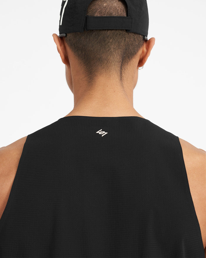 Man wearing a black training vest on a plain white background | 247 Singlet in Jet Black | Perforated singlet with bonded hems | 247 T-Shirts | Represent Clo