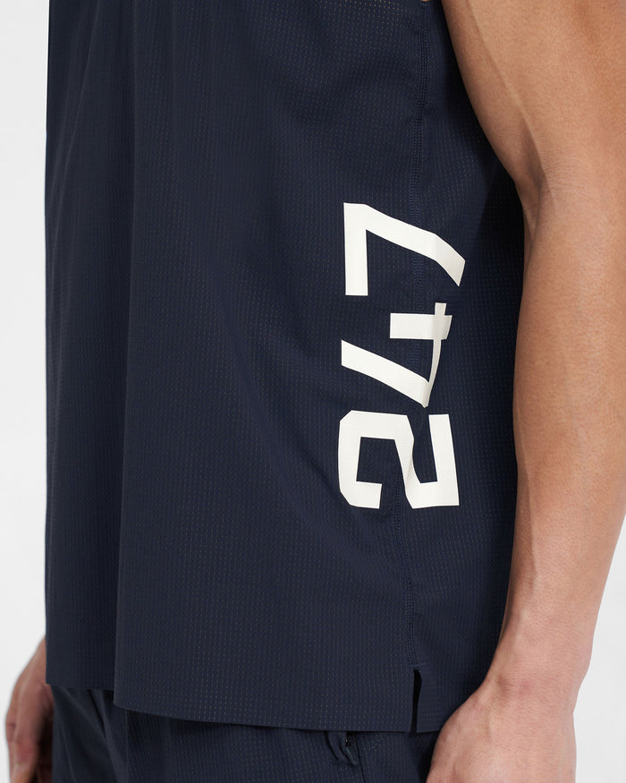 Man wearing a navy training vest on a plain white background | 247 Singlet in Navy | Perforated singlet with flatlock seams and bonded hems | 247 T-Shirts | Represent Clo
