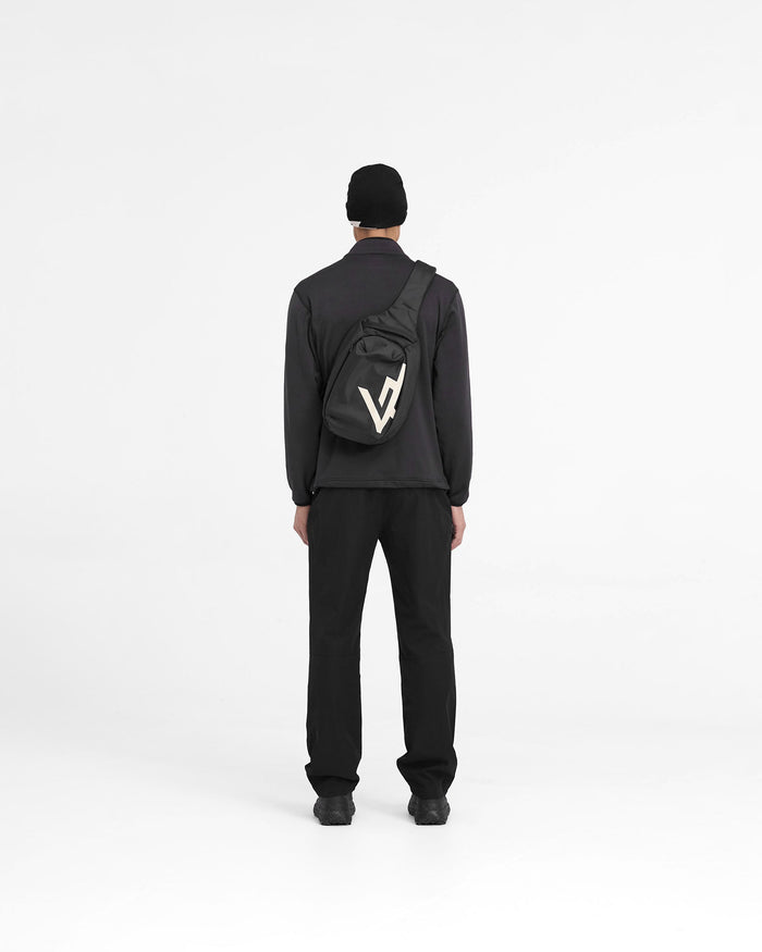 Additional product image of a black sling bag on a plain white background | 247 Sling Bag in Black | Sling bag with zip pockets, adjustable padded strap, and mesh backing | 247 Accessories | Represent Clo