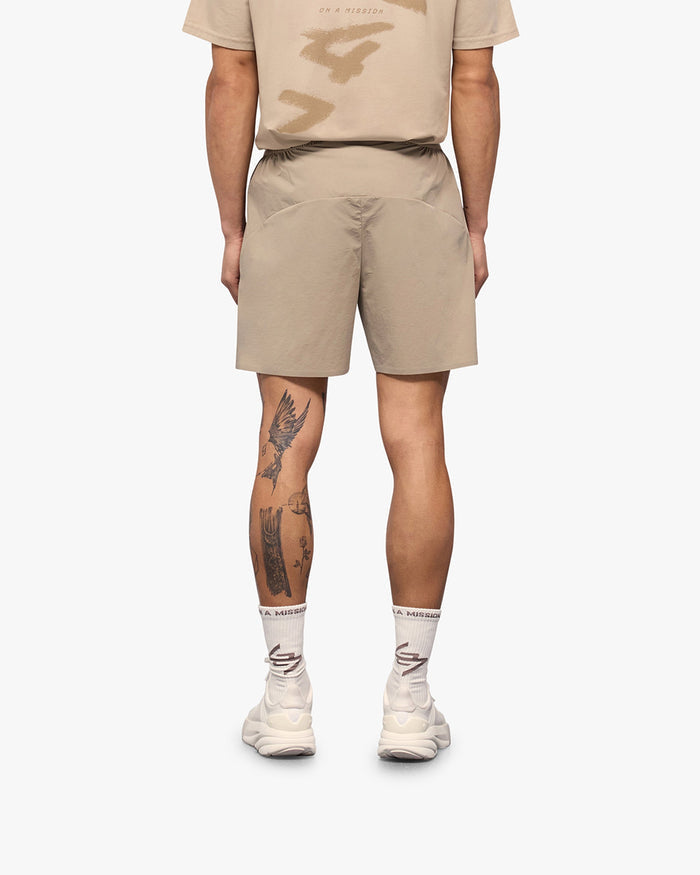 Man wearing grey shorts on a plain white background | 247 Training Shorts in Pebble | High intensity nylon spandex shorts with perforation detailing | 247 Shorts | Represent Clo