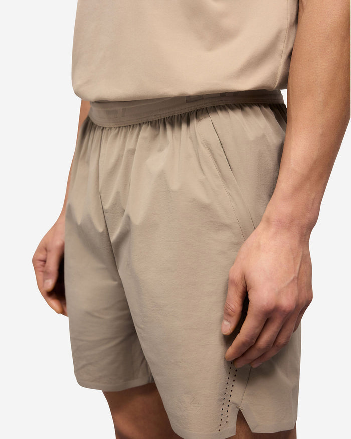 Man wearing grey training shorts on a plain white background | 247 Training Shorts in Pebble | Nylon blend shorts with zip pockets | 247 Shorts | Represent Clo