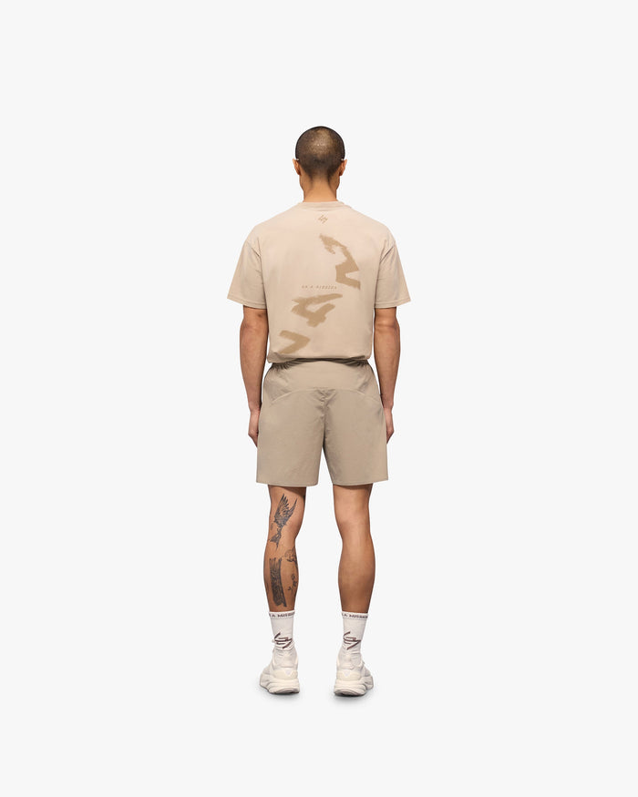 Man wearing grey training shorts on a plain white background | 247 Training Shorts in Pebble | Flexible and breathable shorts with zip pockets | 247 Shorts | Represent Clo