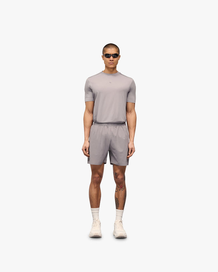 Man wearing grey training shorts on a plain white background | 247 Training Shorts in Titanium | Shorts with perforation detailing and zip pockets | 247 Shorts | Represent Clo