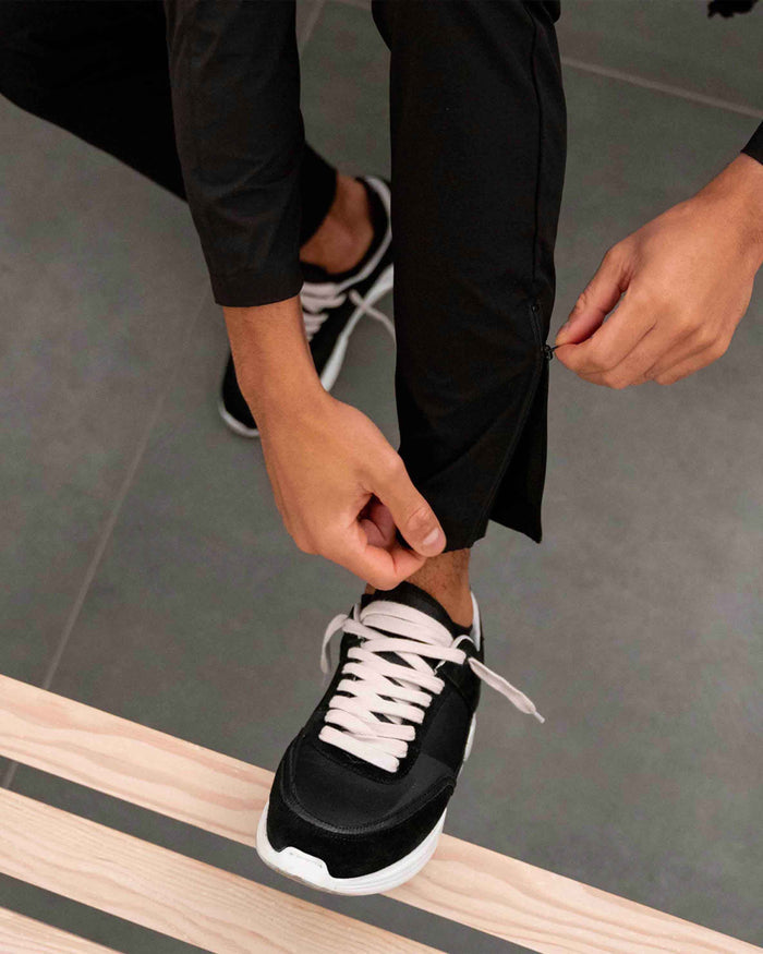 Man wearing black combat trousers on a plain white background | 247 Zip Pant in Black | Combat trousers with ripstop stretch fabric and cargo leg pockets | 247 Pants | Represent Clo