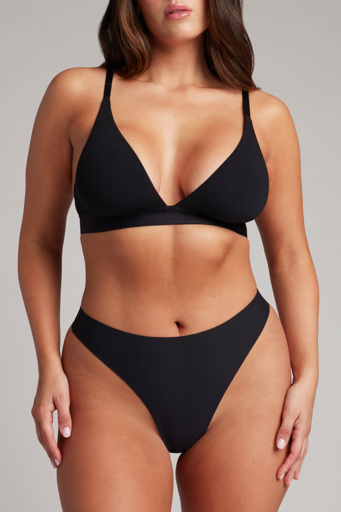 Black high-rise thong with wide waistband, front view on model