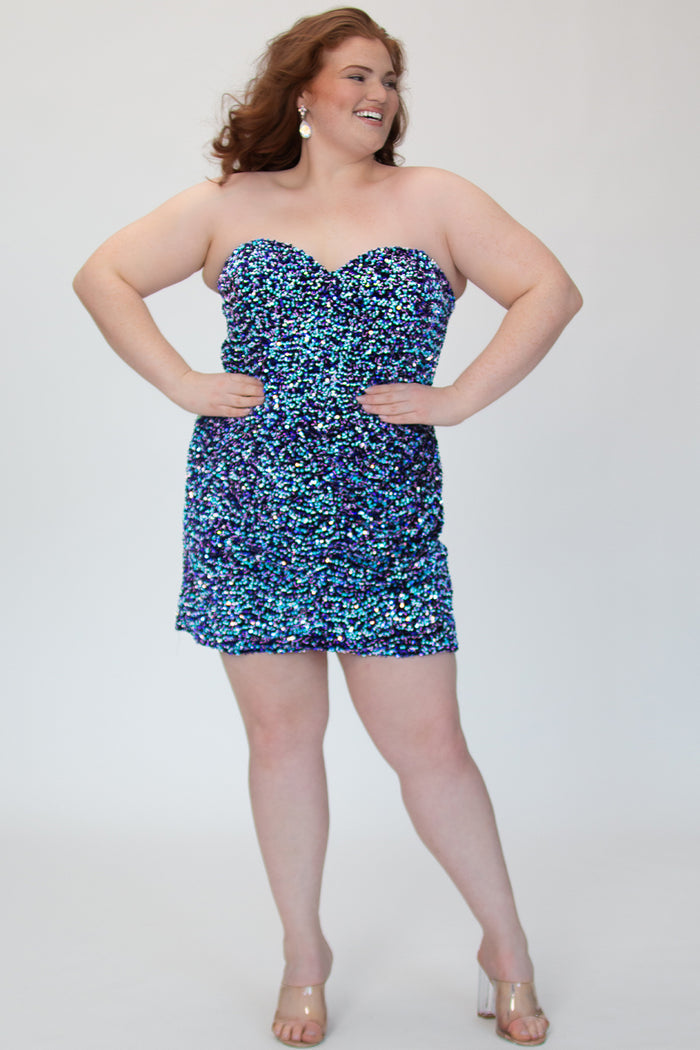 SC8157, plus size short sequin party dress by Sydney's Closet. Front view. A fully multidimensional sequin fabric in the color Galaxy, a mixture of blues and purples. Sweetheart neckline, ruched skirt and long invisible center back zipper. Available in Galaxy, sizes 14-24. Model is 5'9.