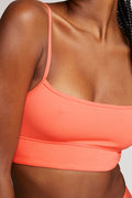 Coral bralette tank with thin shoulder straps and scoop neckline close-up