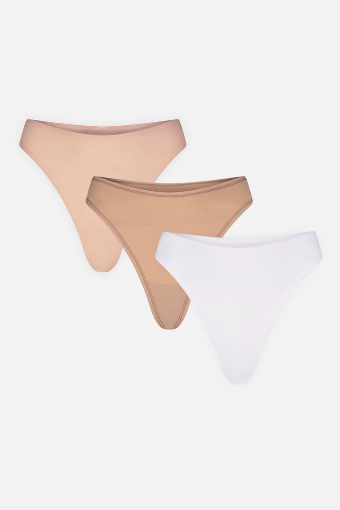 Three cotton thongs laid flat: two honey and one white, high-cut design