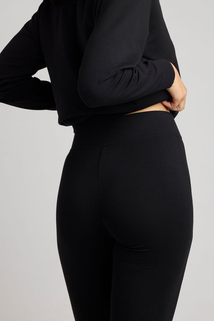 Black flare pants with smooth fabric and subtle back-seam detail