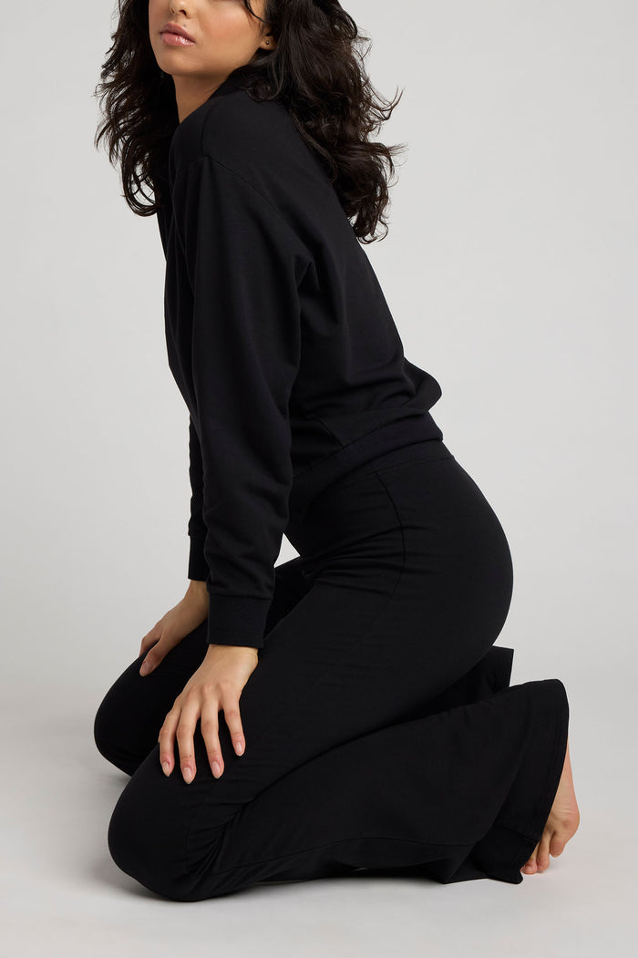 Black flare pants, fitted waist-to-thigh with draped wide leg opening