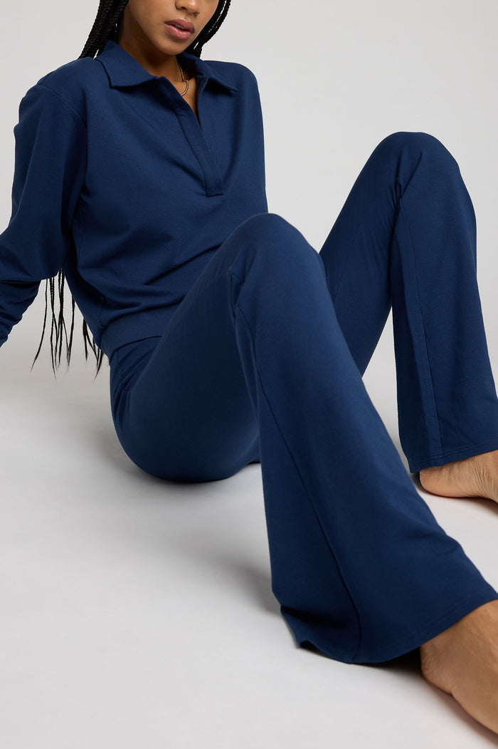Navy flare pants laid out showing wide bell-like leg and elastic waist