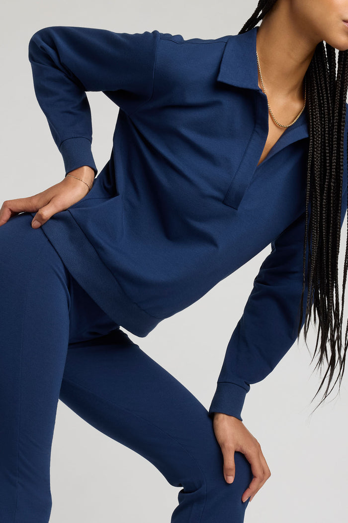 Navy collared pullover with long sleeves and deep V-style neckline, draped fit