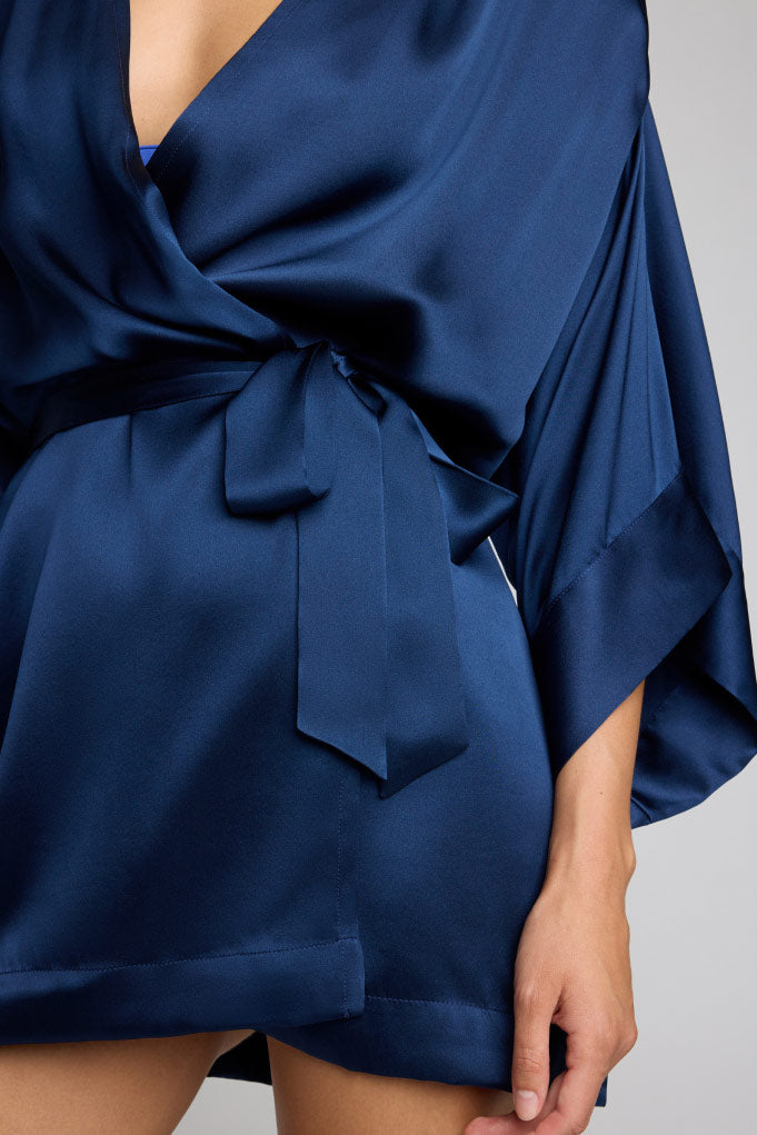 Navy silk mini robe with V-neck and tied waist sash; flowing drape kimono sleeves