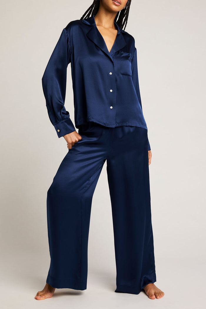 Navy button-up shirt with pointed collar and long sleeves, worn with matching pants