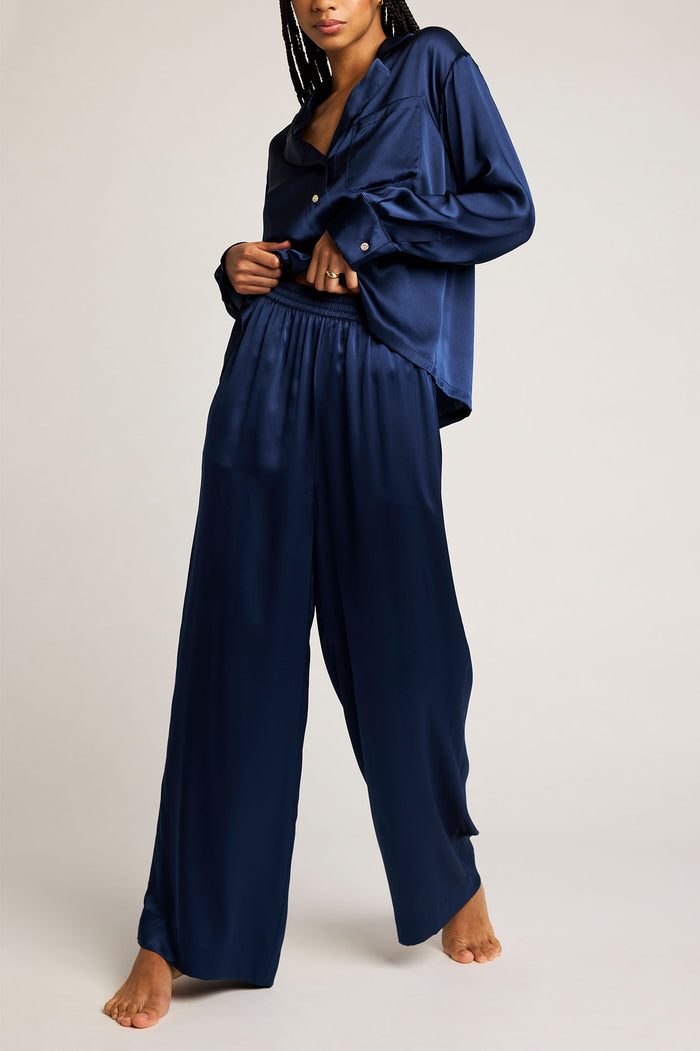 Navy button-up shirt with long sleeves and open V-neck, worn with loose pants