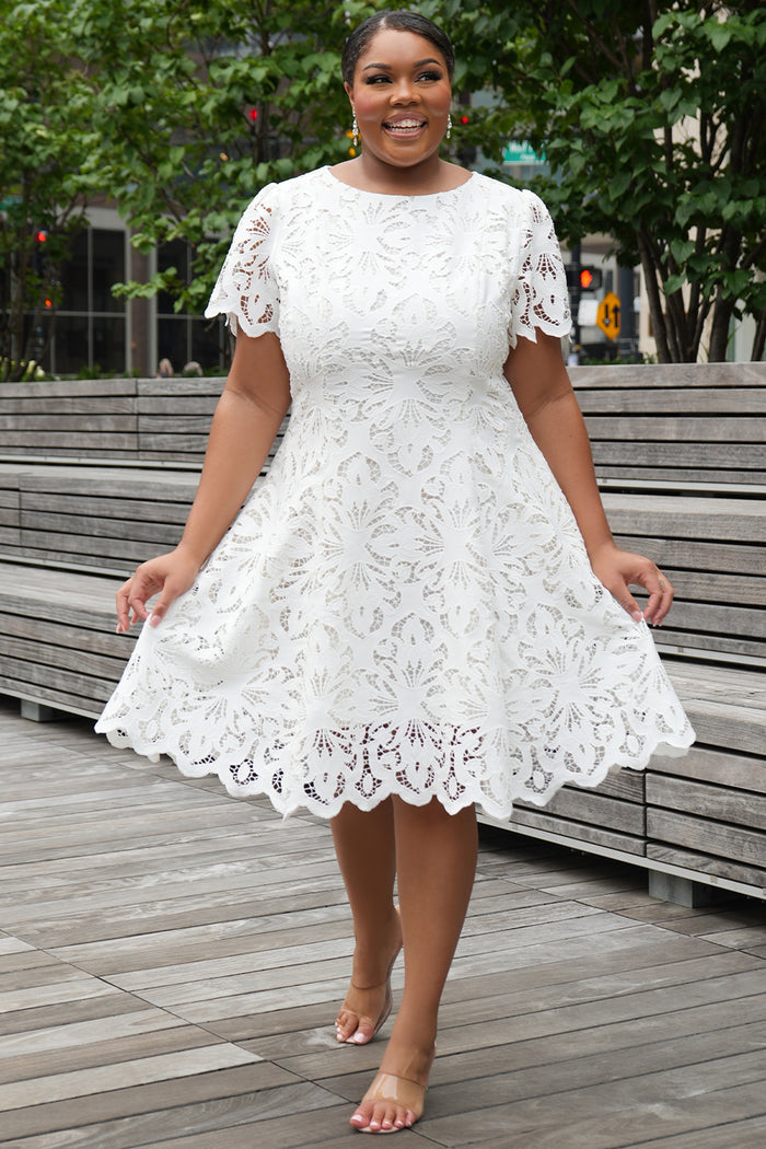 LWD style CE2601 in white. Scoop neckline, short sleeve, scalloped hem on sleeves and hem of dress. Princess silhouette, pockets and elegant Guipere lace. Long invisible center back zipper.  Celebrations by Sydney's Closet