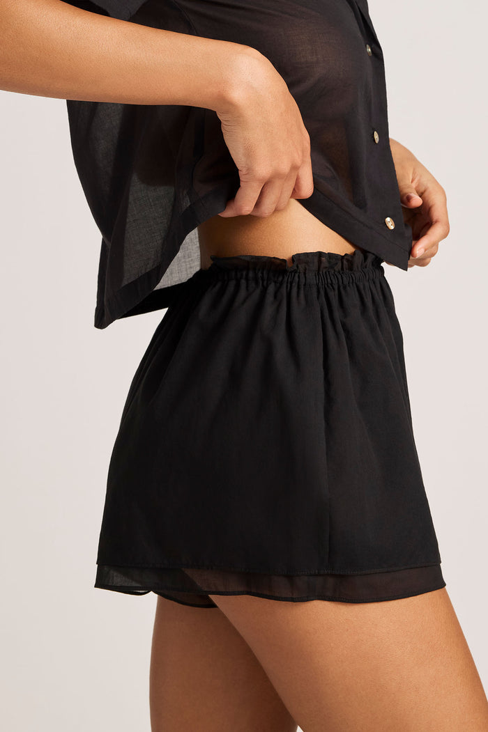 Black elastic-waist play shorts with gathered ruffle hem