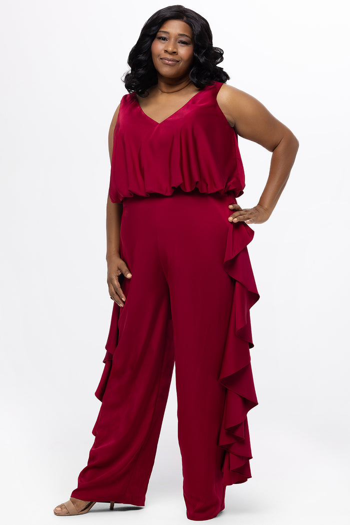 Celebrations by Sydney's Closet Style CE2615 in cherry red.

One-piece crepe satin jumpsuit with ruffled on outer pants seams. Bra-friendly straps, blouson bodice and wide leg pants. Center back zipper and scoop neckline.