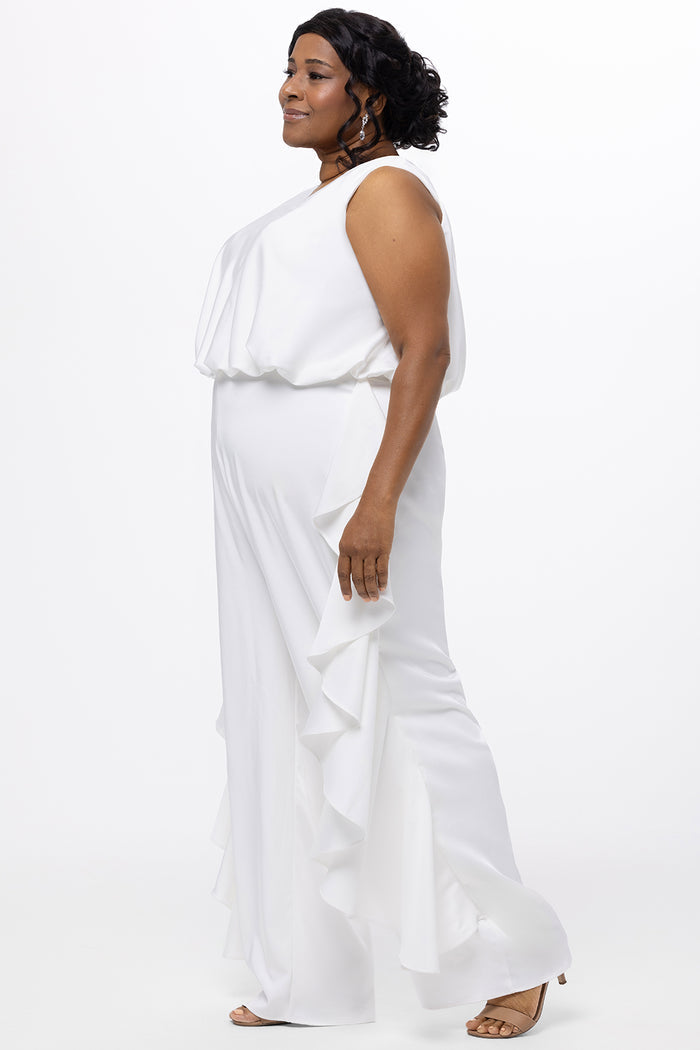 Celebration's by Sydney's Closet style CE2615 in Ivory. 

Crepe satin jumpsuit with a V-neck, bra-friendly straps, wide leg pants and blouson bodice. Ruffle detail on outer seams of pants. V-back with long center back zipper.