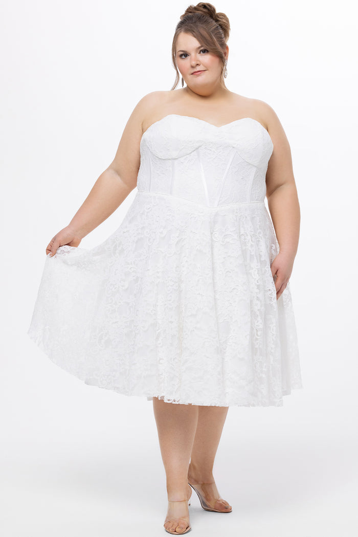 Celebrations by Sydney's Closet Style CE2613 in white. 

Plus size strapless white tea-length dress with sweetheart neckline, exposed corset boning on bustier bodice and tea-length skirt in all over stretch lace.
