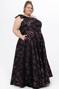 Celebrations by Sydney's Closet Style CE2614 in Pink Rose and Black floral brocade fabric.

Plus size maxi length formal dress. One-shoulder neckline with detachable bow at high point of shoulder, natural waistline and A-line skirt with pockets.
