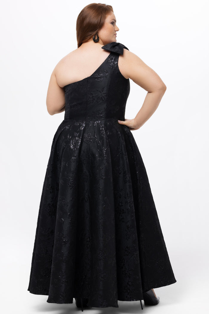 Celebrations by Sydney's Closet Style CE2614 in Black

Plus size maxi length formal dress. One-shoulder neckline with detachable bow at high point of shoulder, natural waistline and A-line skirt with pockets. 

Black floral brocade fabric.