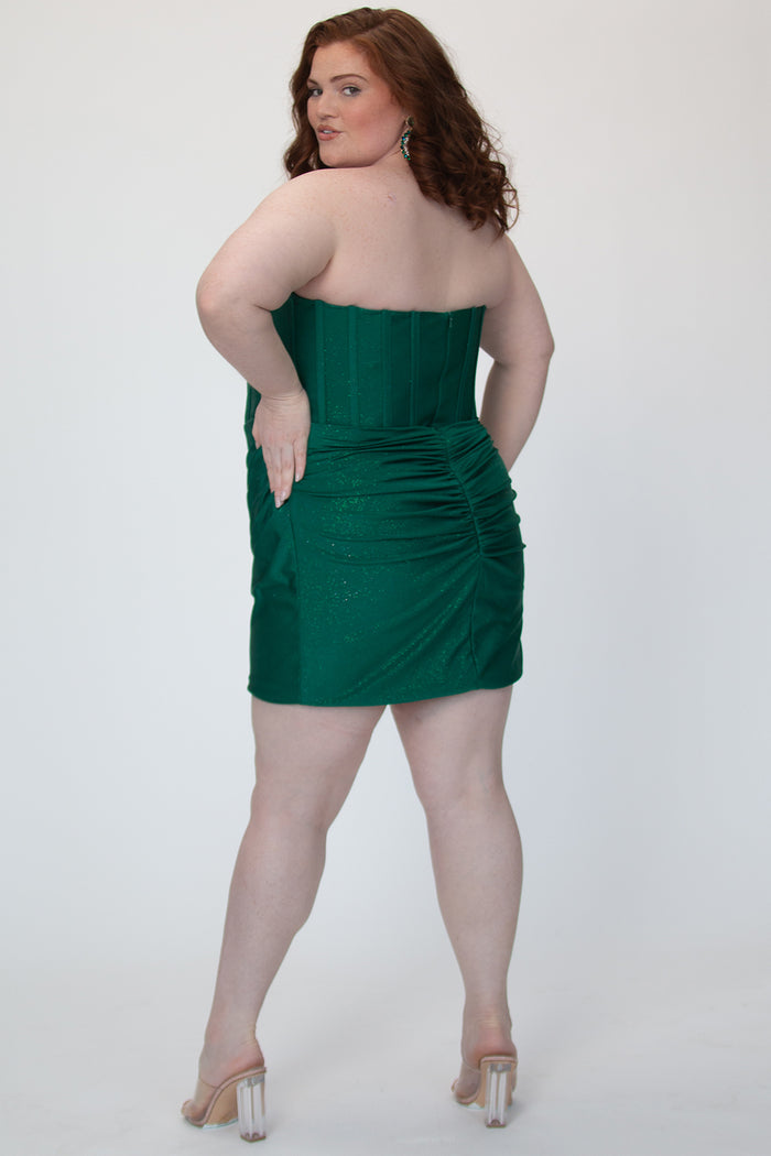 Short fitted green party dress SC8143 by Sydney's Closet. Back view.  Strapless, exposed boning basque waist and ruched fitted skirt in shimmer stretch knit. Availability in black, purple, red, ivory, green and royal. Model in picture is 5'9.
