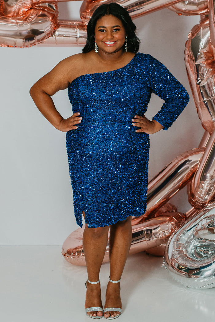 Plus size short sequin party dress with one-shoulder long sleeve, slit and center back zipper. Fabulous jewel tone colors: Hunter Green, Onyx Black, Ruby Red, Pearlescent White or Sapphire Blue. Style SC8112 by Sydney's Closet