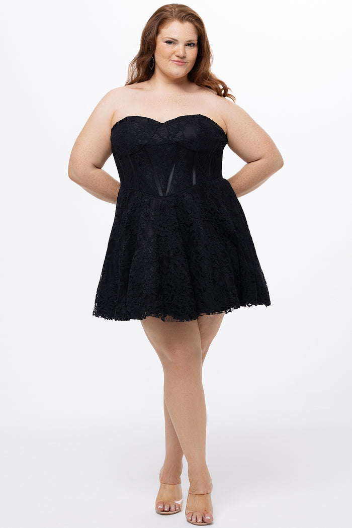 Celebrations by Sydney's Closet Style CE2612 in black. 

Plus size strapless black short mini party dress with sweetheart neckline, exposed corset boning on bustier bodice and mini skirt in all over stretch lace.