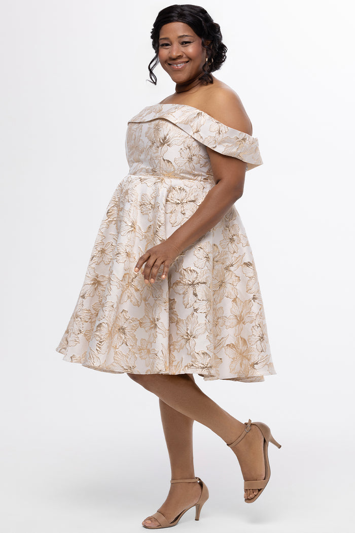 Celebrations by Sydney's Closet CE2610 in Gold Floral. 

Plus size knee-length party dress in metallic gold floral brocde print. Off-the-shoulder neckline, natural waistline and A-line skirt with pockets.